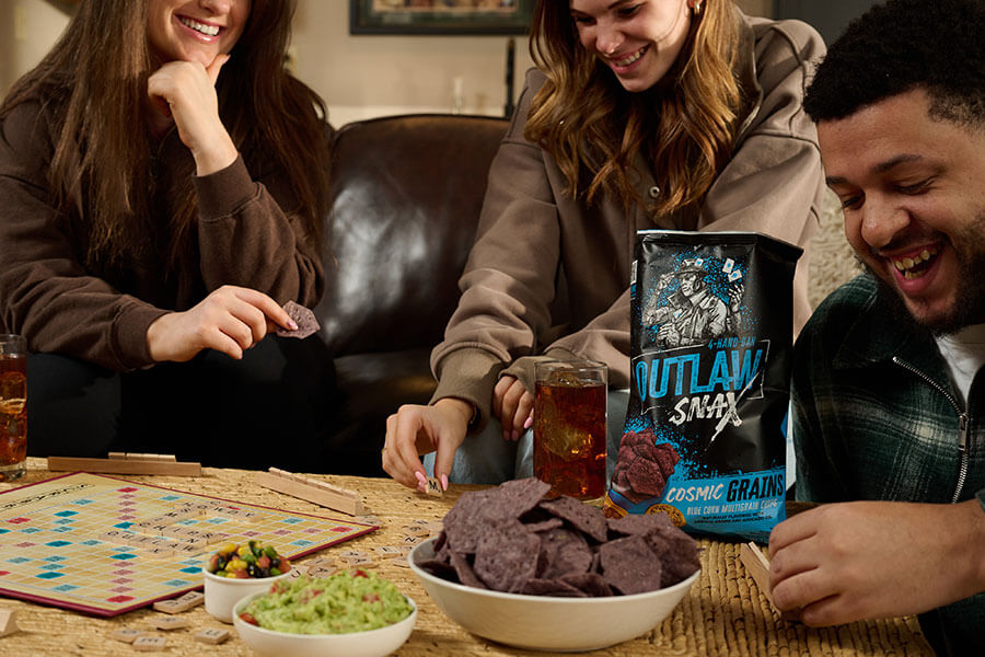 Outlaw Snax Cosmic Grains blue corn multigrain tortilla chips enjoyed during a game night with friends
