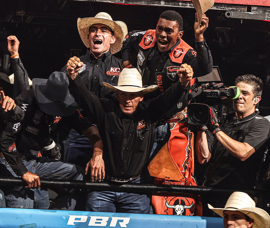 KC Outlaws team members celebrating a successful ride during a Professional Bull Riders event.